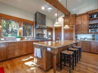 Experience rustic charm in this spacious kitchen featuring custom wood cabinetry and granite countertops.