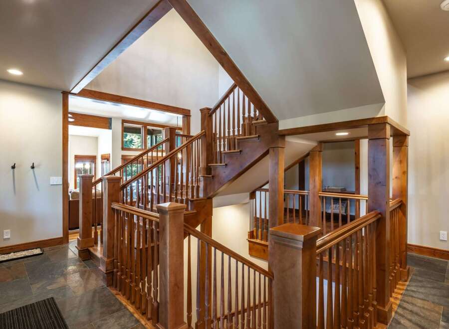 Experience the grandeur of this stunning home featuring a magnificent wooden staircase that serves as the centerpiece of the entryway.