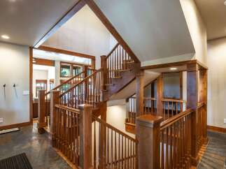 Experience the grandeur of this stunning home featuring a magnificent wooden staircase that serves as the centerpiece of the entryway.