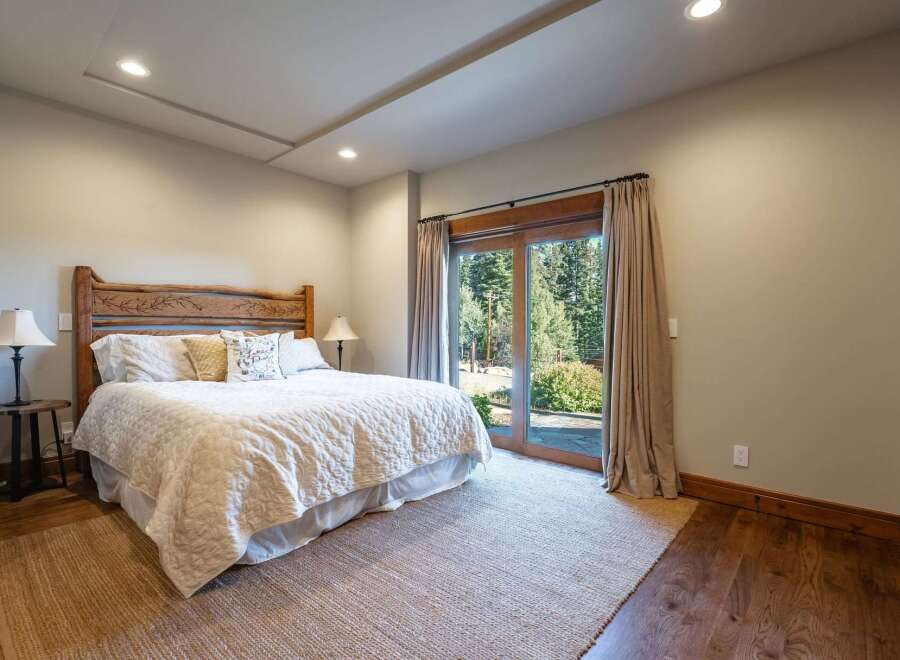 Experience serene mountain living in this charming bedroom, featuring a rustic wooden headboard and a plush white comforter.