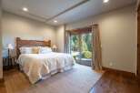 Experience serene mountain living in this charming bedroom, featuring a rustic wooden headboard and a plush white comforter.