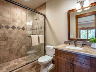 Experience luxury in this beautifully appointed bathroom, featuring a spacious walk-in shower with elegant tilework and a decorative accent band.