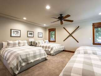 This spacious bedroom offers comfortable sleeping arrangements with three beds, each adorned with charming checkered bedding.