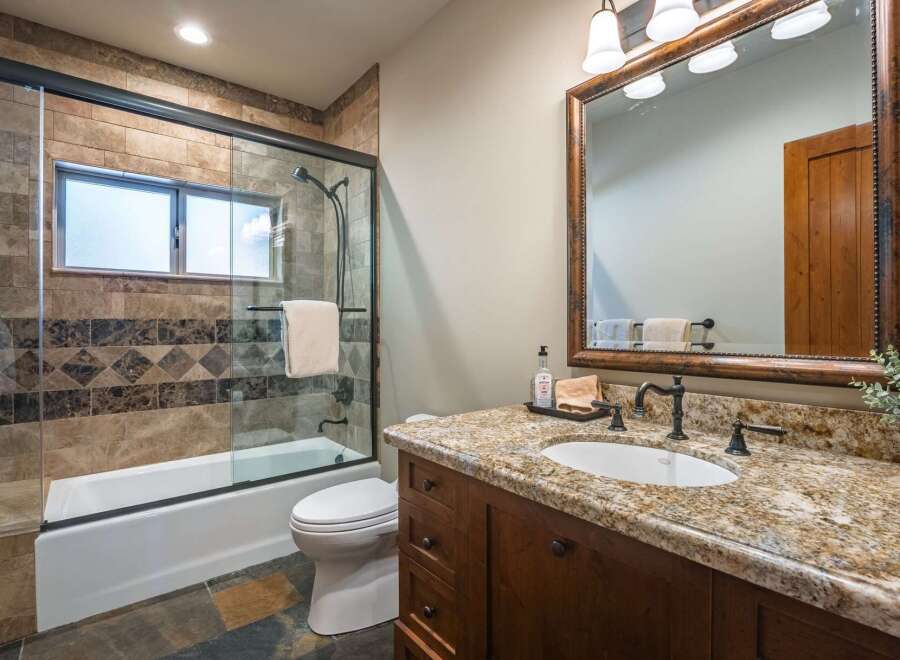 This beautifully appointed bathroom features a spacious walk-in shower with elegant tile work and a convenient bathtub.