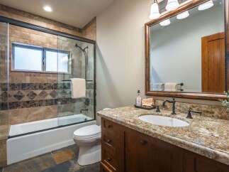 This beautifully appointed bathroom features a spacious walk-in shower with elegant tile work and a convenient bathtub.