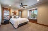 Experience rustic charm in this inviting bedroom, featuring a comfortable bed adorned with decorative pillows and a large wooden star accent.