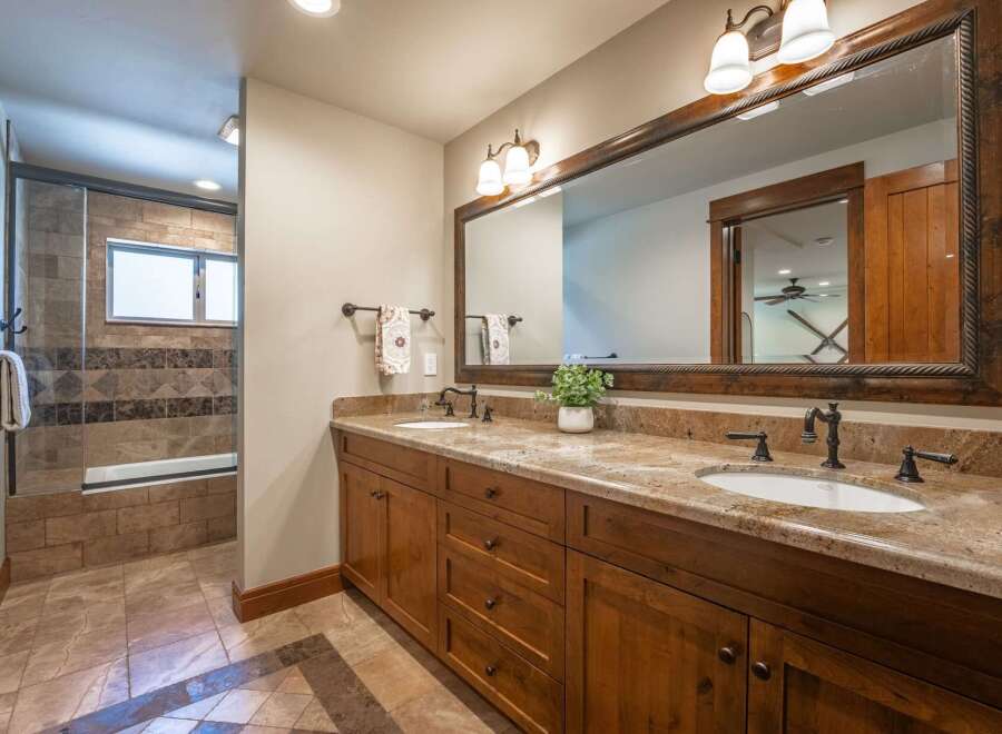 This spacious bathroom features a double vanity with granite countertops and ample storage, perfect for any household.