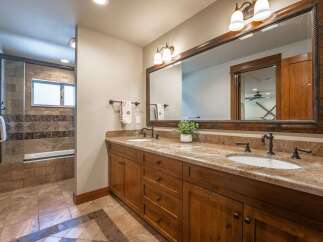 This spacious bathroom features a double vanity with granite countertops and ample storage, perfect for any household.