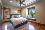 Experience ultimate relaxation in this serene bedroom, featuring a plush king-size bed adorned with decorative pillows and a cozy window seat offering breathtaking forest views.