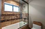 This luxurious bathroom features a deep soaking tub with a glass enclosure, perfect for unwinding after a long day.