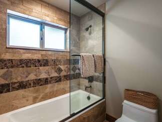This luxurious bathroom features a deep soaking tub with a glass enclosure, perfect for unwinding after a long day.