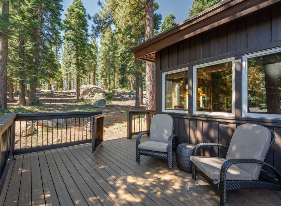 Enjoy the serene mountain setting from this spacious wooden deck, perfect for outdoor relaxation.