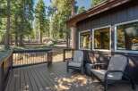 Enjoy the serene mountain setting from this spacious wooden deck, perfect for outdoor relaxation.
