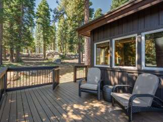 Enjoy the serene mountain setting from this spacious wooden deck, perfect for outdoor relaxation.