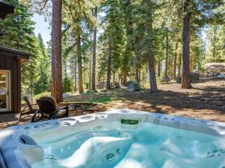 Indulge in ultimate relaxation with this luxurious hot tub, perfectly situated on a private deck surrounded by a serene forest landscape.