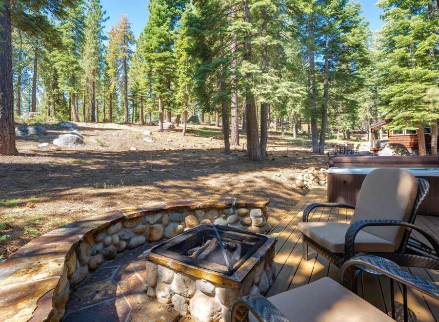 Enjoy the serene mountain lifestyle with this stunning property featuring a cozy stone fire pit and a luxurious hot tub, perfect for relaxing evenings.