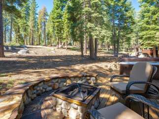 Enjoy the serene mountain lifestyle with this stunning property featuring a cozy stone fire pit and a luxurious hot tub, perfect for relaxing evenings.