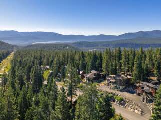 Nestled amidst a dense forest of towering pine trees, this stunning property offers a serene mountain retreat.