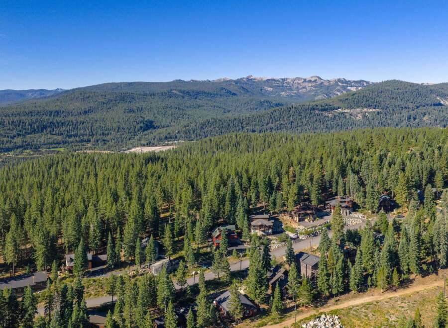 Nestled amidst a dense forest of evergreen trees, this property offers a serene mountain retreat.
