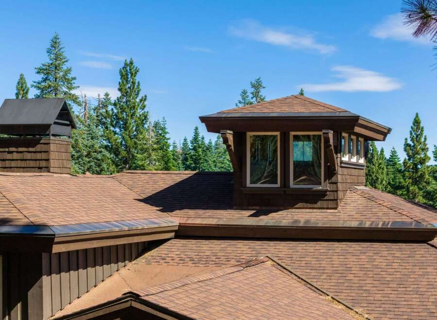 Experience the architectural charm of this mountain retreat, featuring a distinctive multi-level roofline and a prominent dormer window.