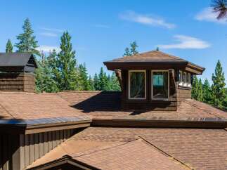 Experience the architectural charm of this mountain retreat, featuring a distinctive multi-level roofline and a prominent dormer window.