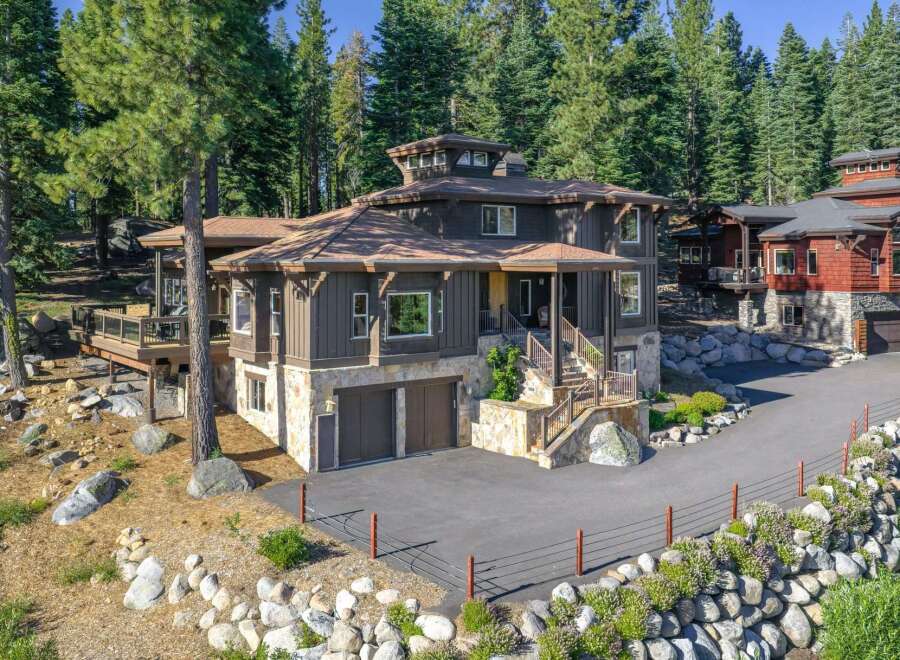 Nestled amidst towering pine trees, this stunning mountain home offers a luxurious retreat with its multi-level design and natural stone accents.