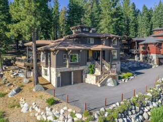 Nestled amidst towering pine trees, this stunning mountain home offers a luxurious retreat with its multi-level design and natural stone accents.