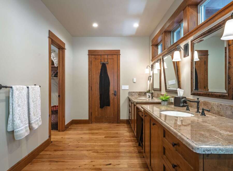 This spacious bathroom features a double vanity with granite countertops and ample storage.