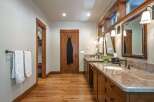 This spacious bathroom features a double vanity with granite countertops and ample storage.
