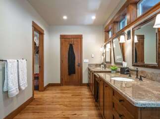 This spacious bathroom features a double vanity with granite countertops and ample storage.