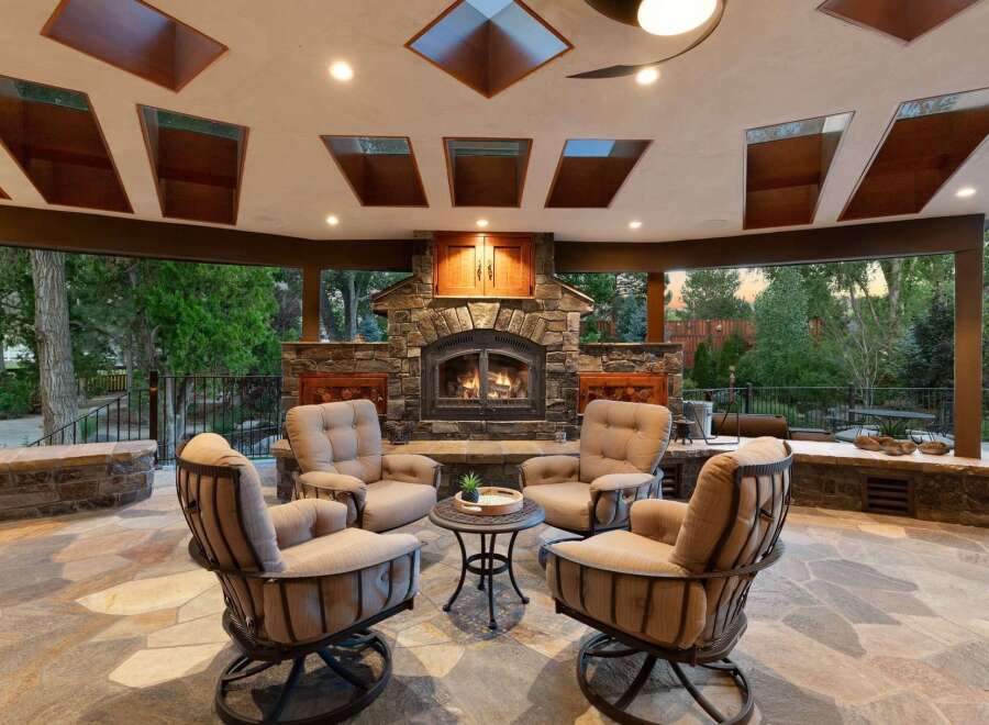 Experience ultimate outdoor living with this stunning covered patio, featuring a grand stone fireplace perfect for cozy evenings.