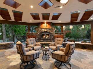 Experience ultimate outdoor living with this stunning covered patio, featuring a grand stone fireplace perfect for cozy evenings.