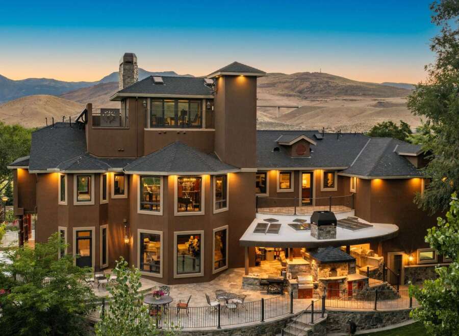 Experience luxury living in this stunning multi-level home, featuring a sprawling outdoor entertainment area with a built-in grill and pizza oven.