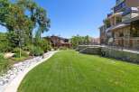 This stunning backyard offers a lush green lawn perfect for recreation and relaxation, bordered by a charming rock garden and mature trees.