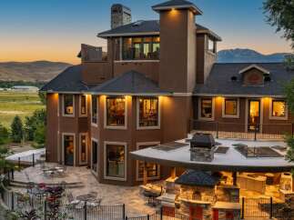 Experience luxury living in this stunning custom-built home, featuring a sprawling outdoor entertainment area with a built-in grill and pizza oven.
