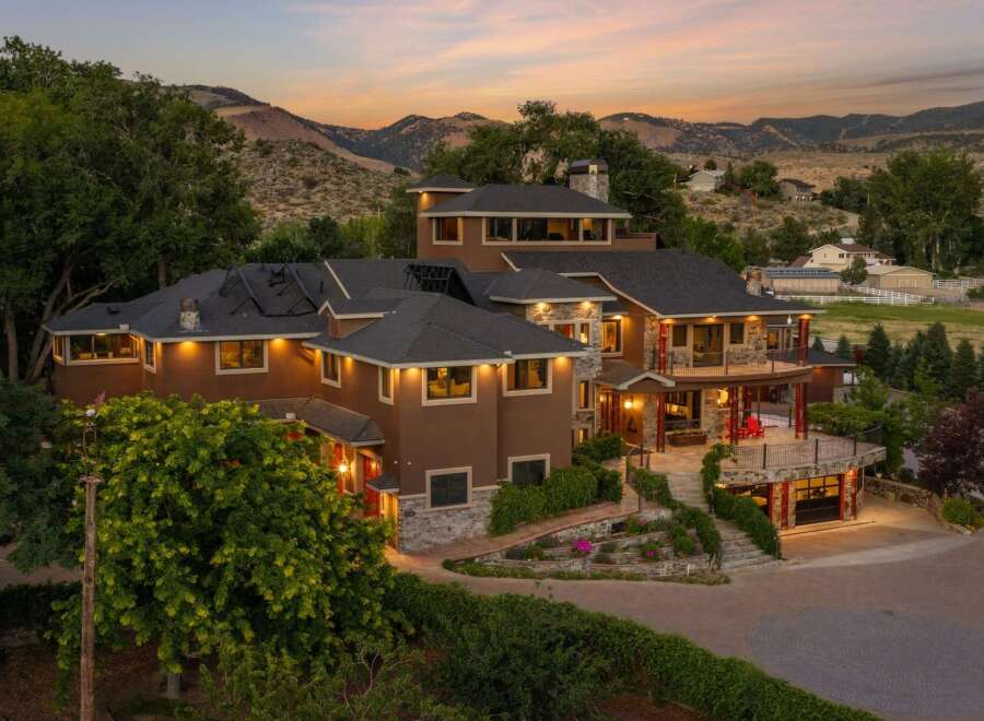 Experience luxury living in this stunning multi-level estate nestled against a scenic mountain backdrop.