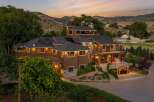 Experience luxury living in this stunning multi-level estate nestled against a scenic mountain backdrop.