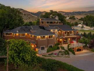 Experience luxury living in this stunning multi-level estate nestled against a scenic mountain backdrop.