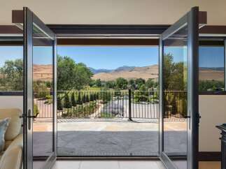 Experience breathtaking panoramic views from this stunning property, featuring expansive glass doors that open to a picturesque landscape.