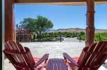 Enjoy breathtaking mountain views from this stunning property's expansive patio, complete with comfortable Adirondack chairs and a charming side table.
