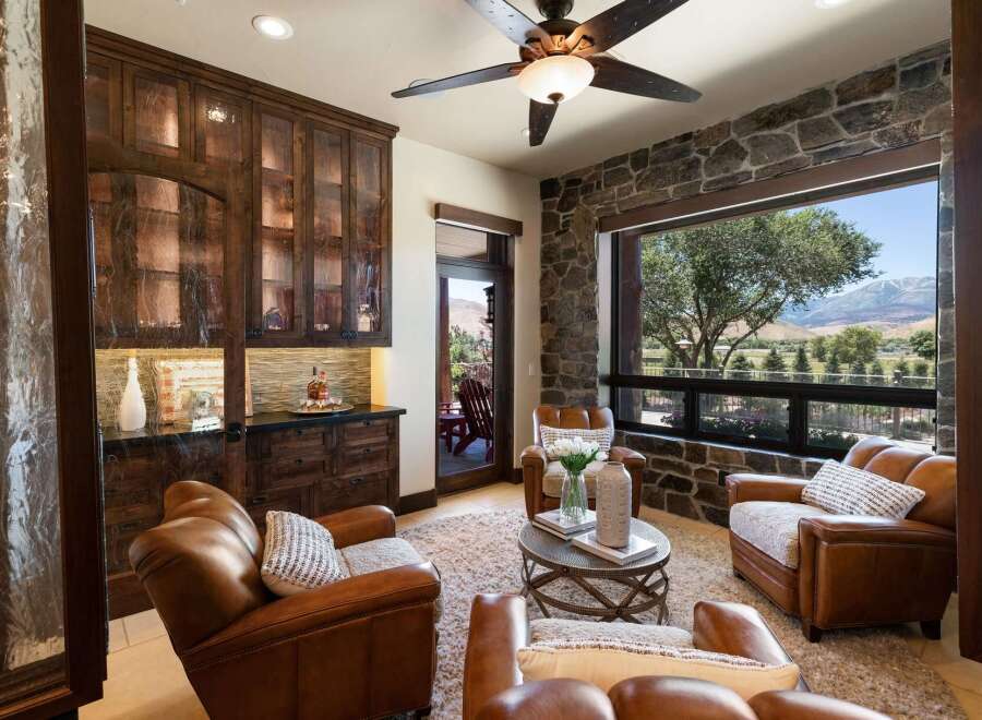 Experience luxury living in this stunning room featuring rich, dark wood cabinetry with glass fronts, perfect for displaying your finest collections.