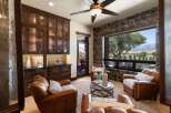 Experience luxury living in this stunning room featuring rich, dark wood cabinetry with glass fronts, perfect for displaying your finest collections.