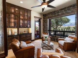 Experience luxury living in this stunning room featuring rich, dark wood cabinetry with glass fronts, perfect for displaying your finest collections.