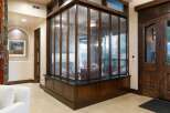 Step into this grand entryway featuring a stunning textured glass partition with rich wood framing, creating a unique visual element.