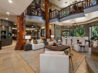 Experience luxury living in this grand great room, featuring a stunning natural wood pillar and a soaring two-story balcony.