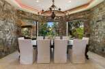 Experience elegant dining in this stunning room featuring a grand chandelier and floor-to-ceiling stone walls.