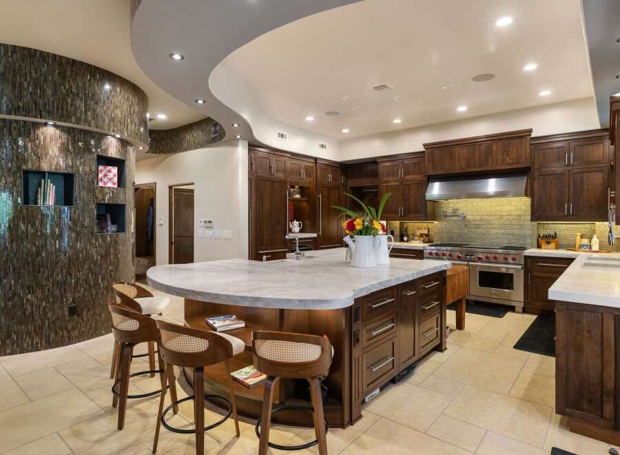 Experience luxury in this stunning gourmet kitchen, featuring a large marble-topped island perfect for entertaining.