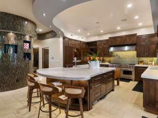 Experience luxury in this stunning gourmet kitchen, featuring a large marble-topped island perfect for entertaining.
