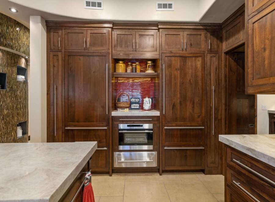 Experience luxury in this stunning kitchen featuring custom dark wood cabinetry that exudes warmth and sophistication.