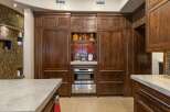 Experience luxury in this stunning kitchen featuring custom dark wood cabinetry that exudes warmth and sophistication.